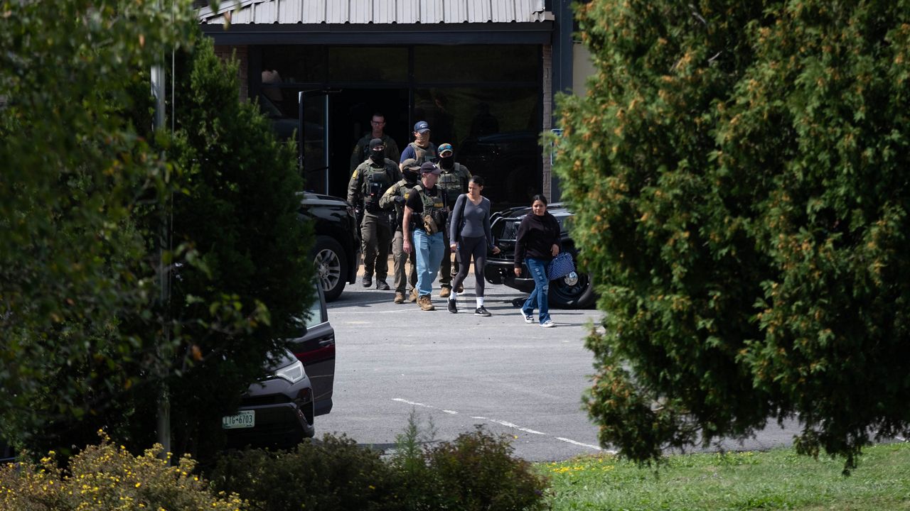 Workers are led out of the factory on Sept. 4, 2025.