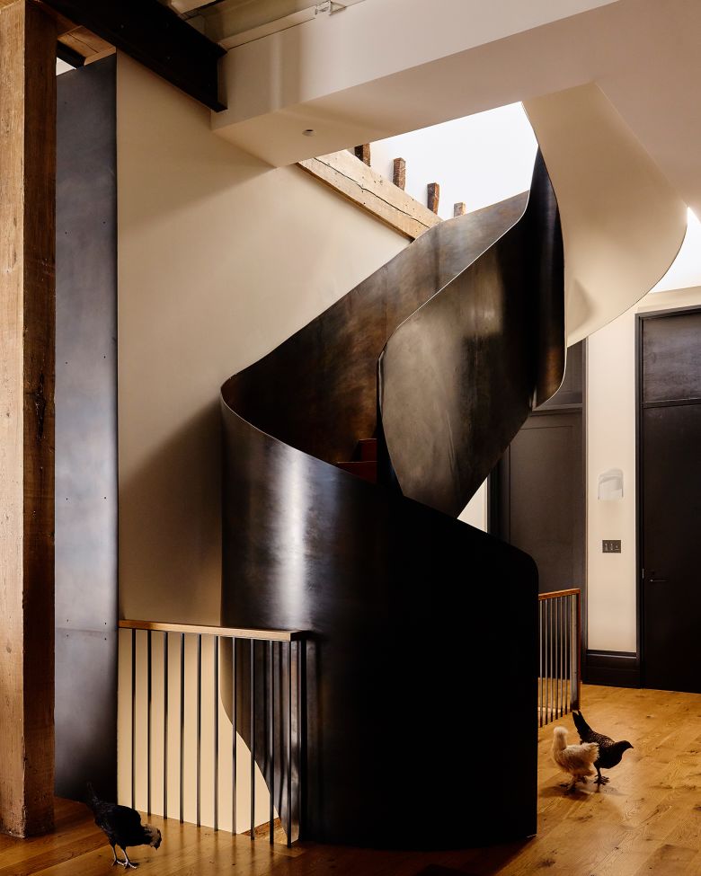 A blackened-steel spiral staircase serves as an architectural centerpiece.