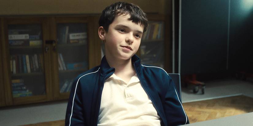 Jamie in a chair with a small smile in Adolescence