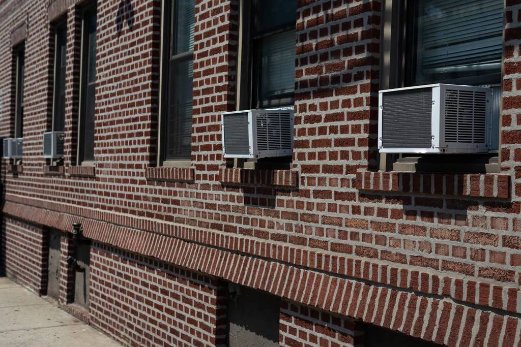 Air conditioner units installed on an NYC brick residential building.