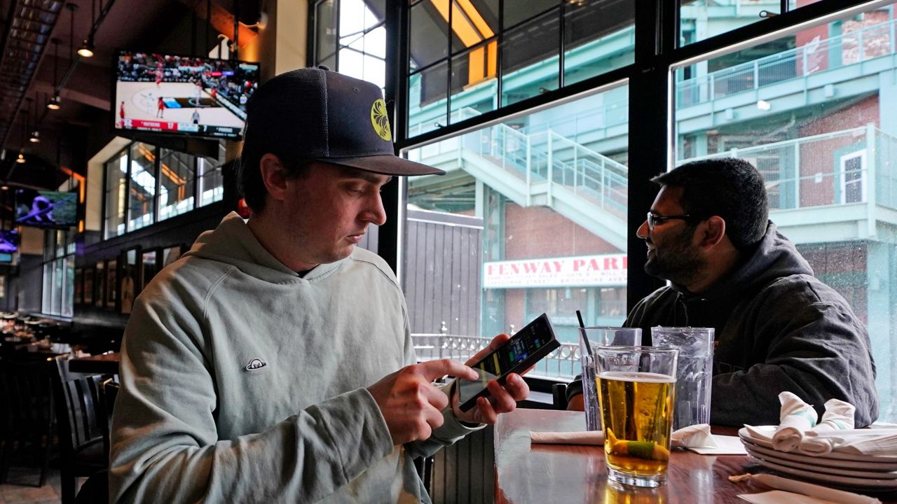 Man at bar holding a phone