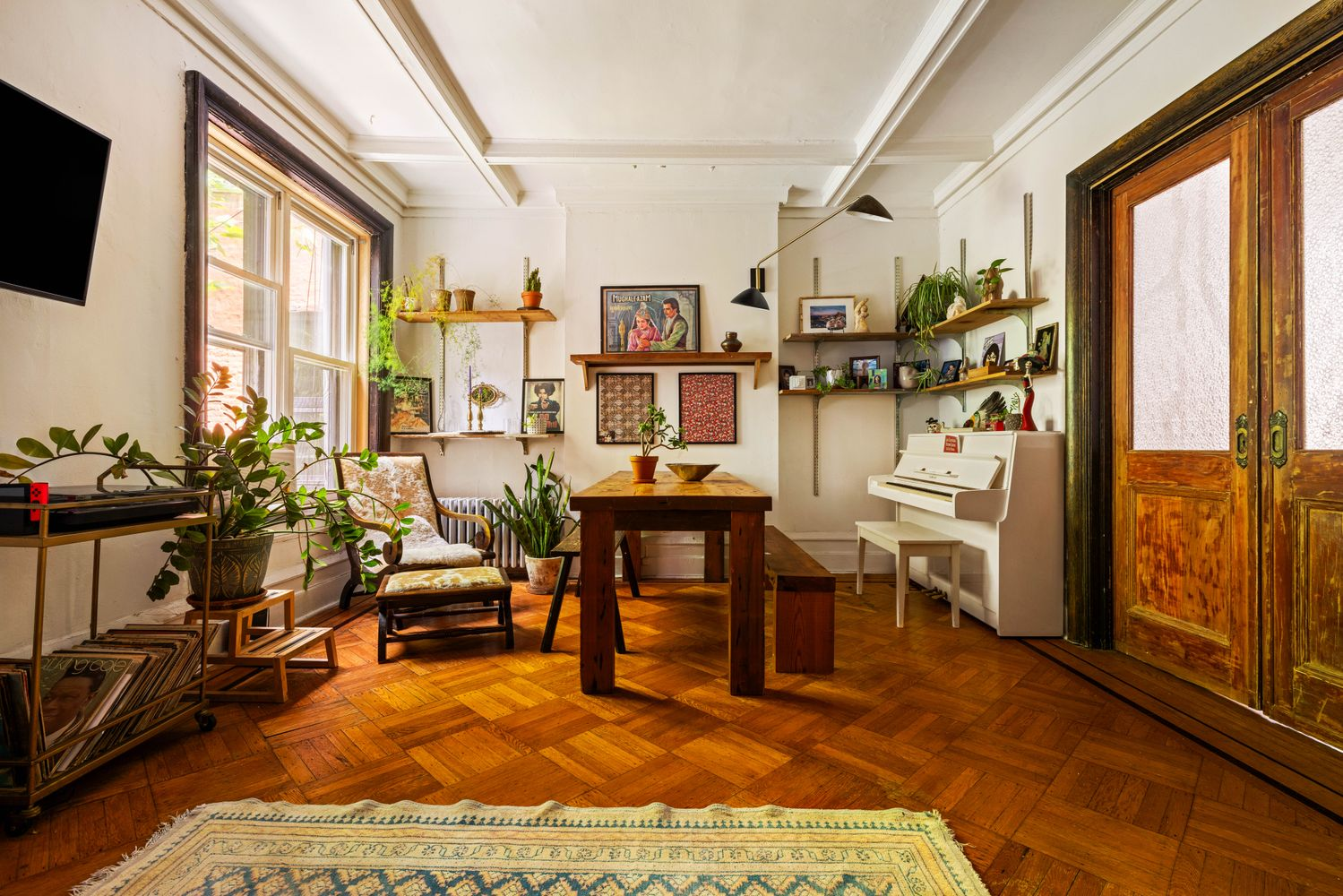 living room with pocket doors, beamed ceiling, wood floor