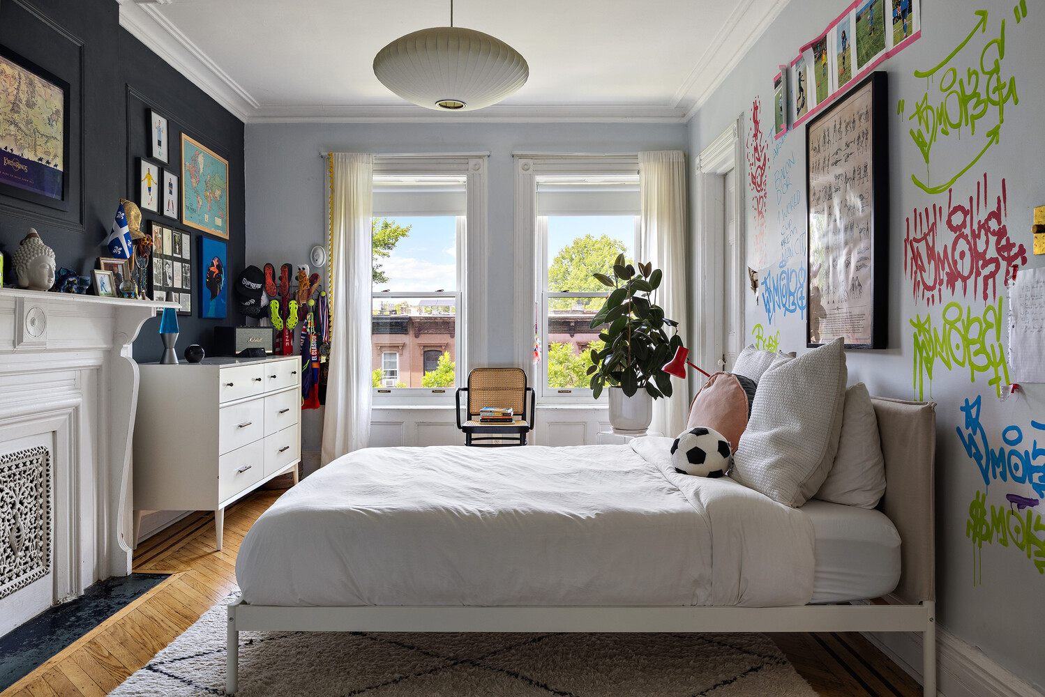 bedroom with blue walls, mantel, two windows
