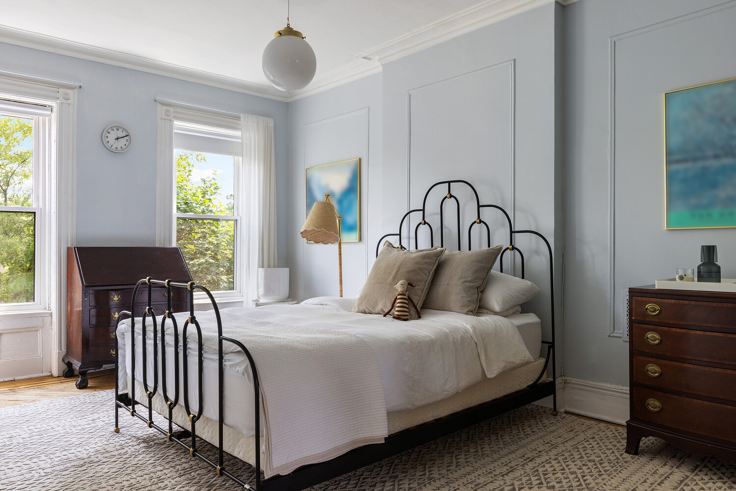 bedroom with pale blue walls, wall moldings
