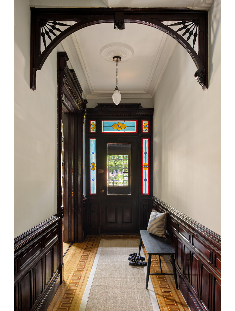 entry hall with wainscoting, fretwork and front door with stained glass