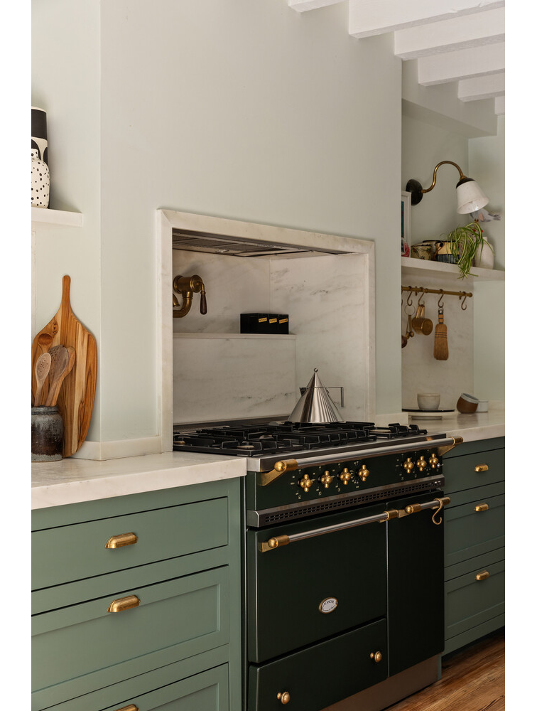 kitchen with stove in niche, green cabinets