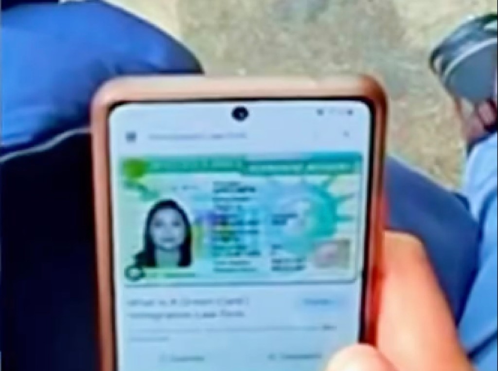 A smartphone displays an image of a counterfeit green card.