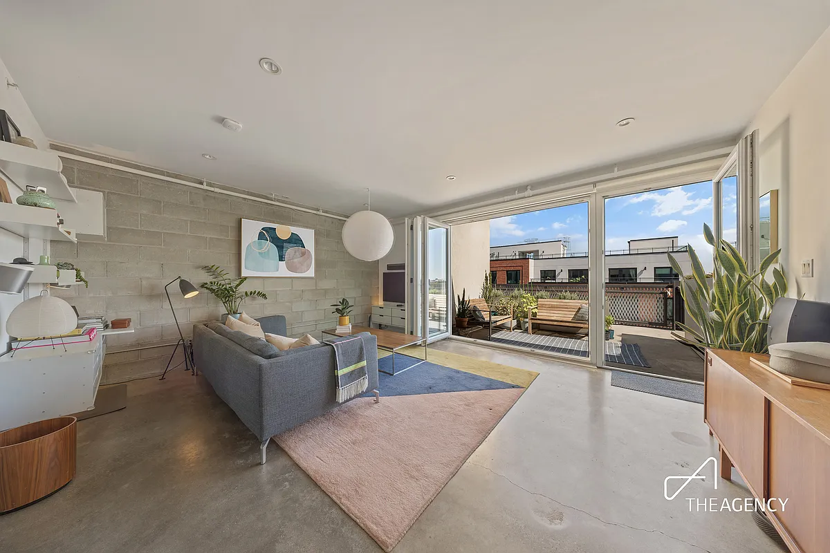 living room with a concrete block wall and a wall of glass with view to terrace