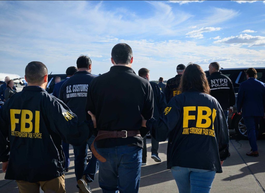 Davud Ansariy, center, surrounded by members of the FBI, US Customs and Border Protection, and NYPD.