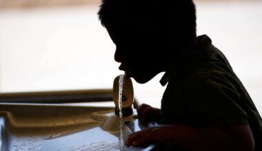 A student drinks from a water fountain