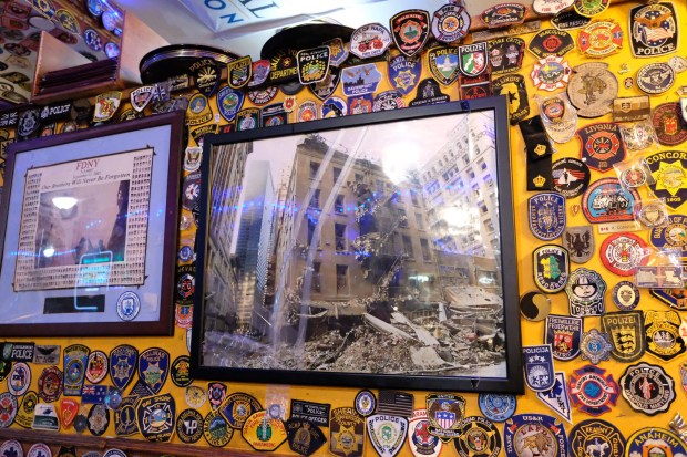 Police and fire memorabilia is displayed in O'Hara's Restaurant & Pub on Cedar St. in Manhattan, as well as a photo of the pub after the 9/11 attacks. (Emma Seiwell / New York Daily News)