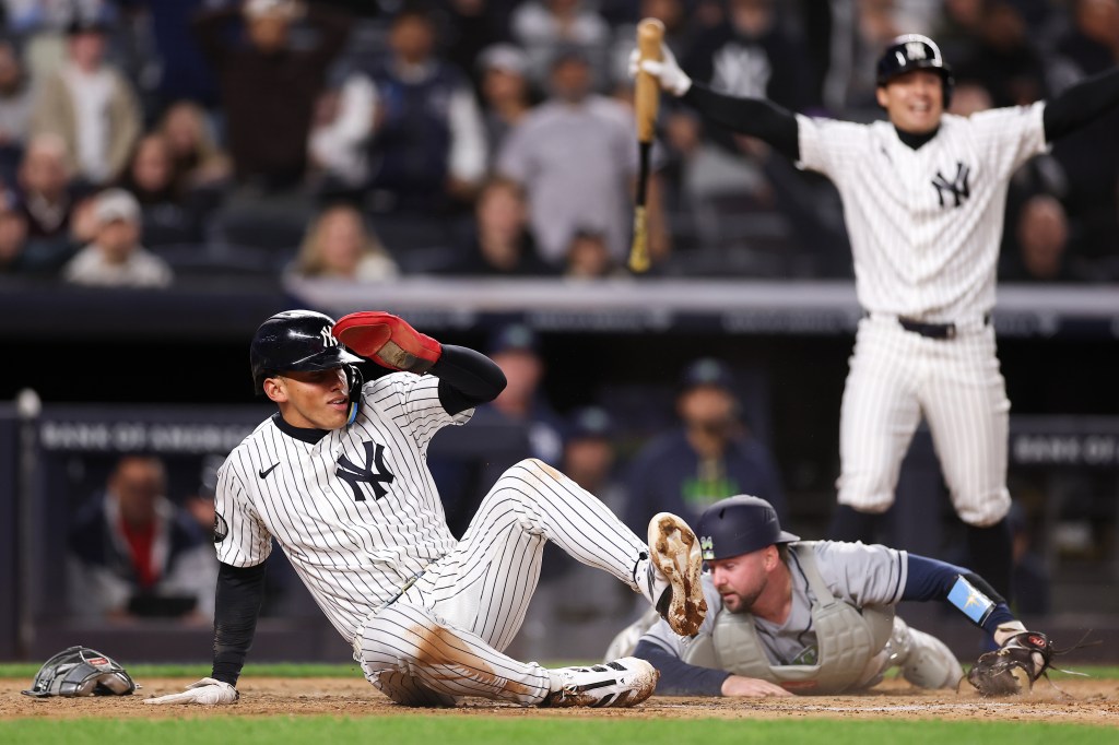 George Lombard Jr. avoids a tag by Liam Hicks of the Tampa Bay Rays to score a run.