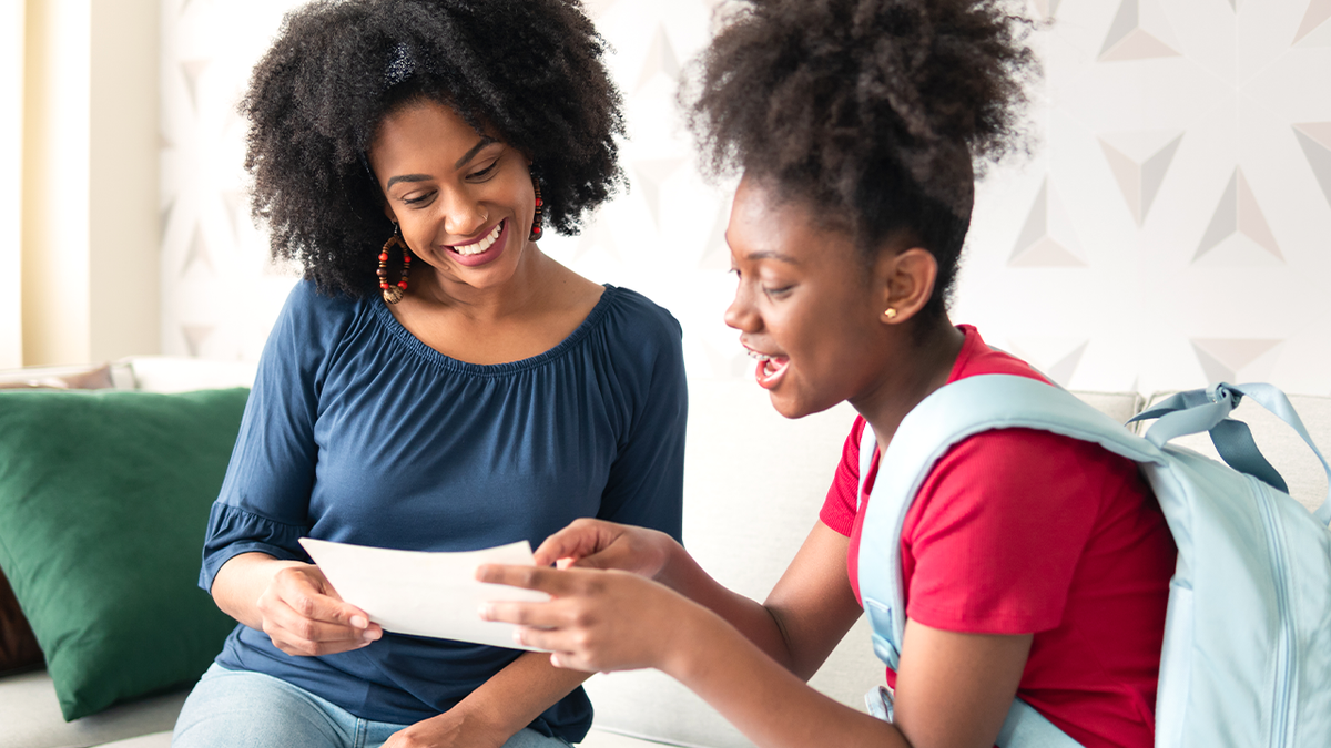 Teenager holds school report card in stock image.