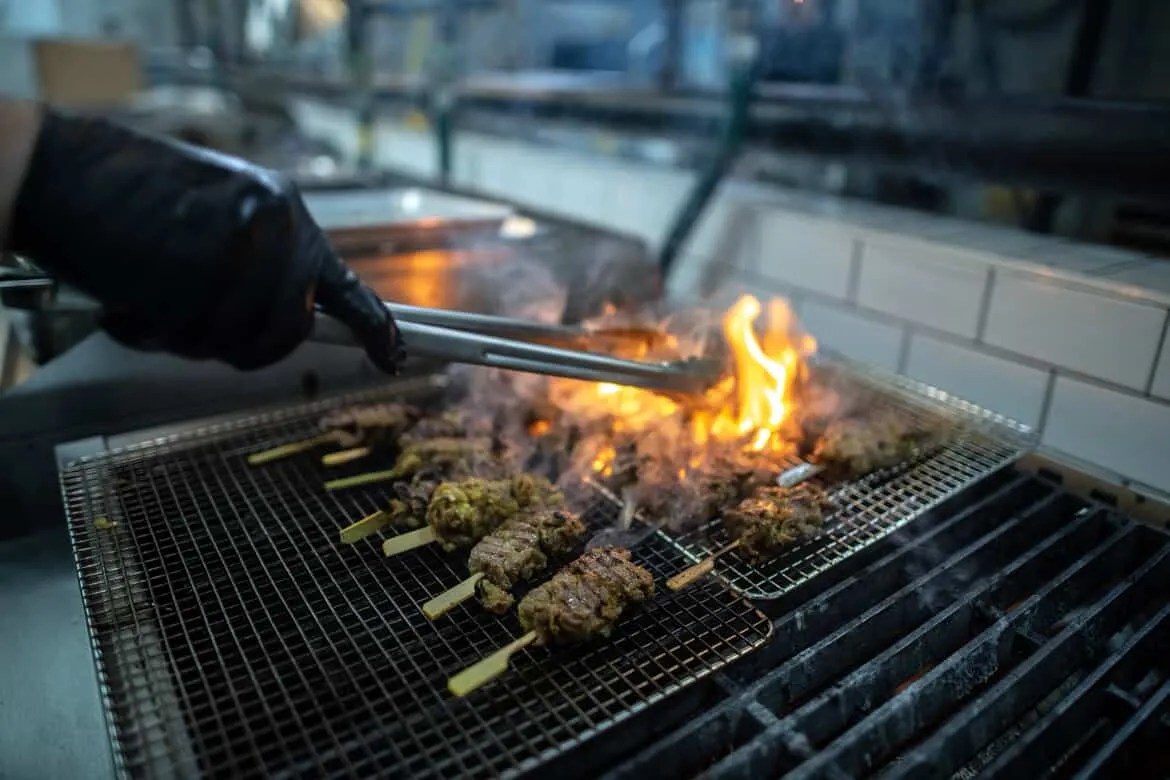 Someone grilling up meat skewers.
