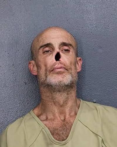 Mugshot of a bald man with a missing nose.