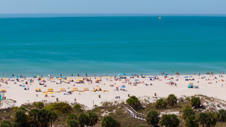 Crowds of people on the sand of St. Pete Beach in Florida with turquoise water