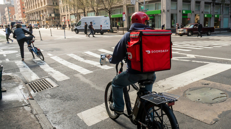A delivery worker on a bike making a DoorDash delivery in New York.