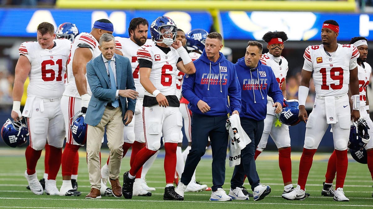 Jaxson Dart walks off the field with an injury during an NFL game.