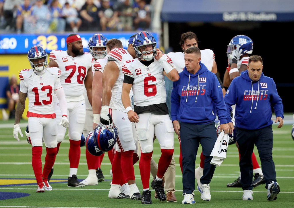 New York Giants quarterback Jaxson Dart (6) is checked by trainers after a hard hit during a game against the Los Angeles Rams at SoFi Stadium.