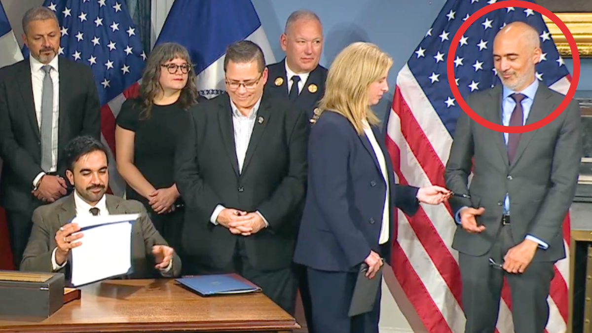 NYPD Commissioner Jessica Tisch hands a ceremonial pen to Ramzi Kassem, who once represented a convicted al Qaeda member tied to a 9/11 hijacker.