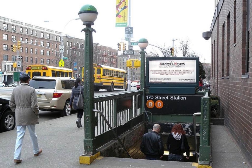 The entrance to the 170th Street subway station in the Bronx, with people walking on the sidewalk and buses in the street.