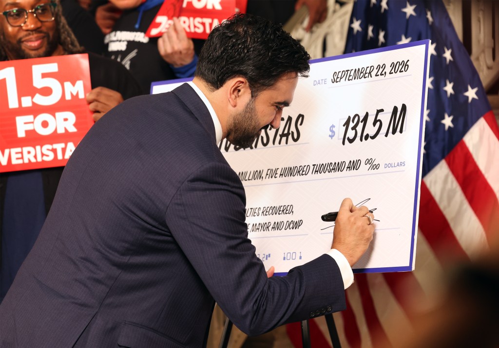 Mayor Zohran Mamdani signing a ceremonial check at a press conference to announce a $131.5 million settlement with DoorDash on Sept. 22, 2026.