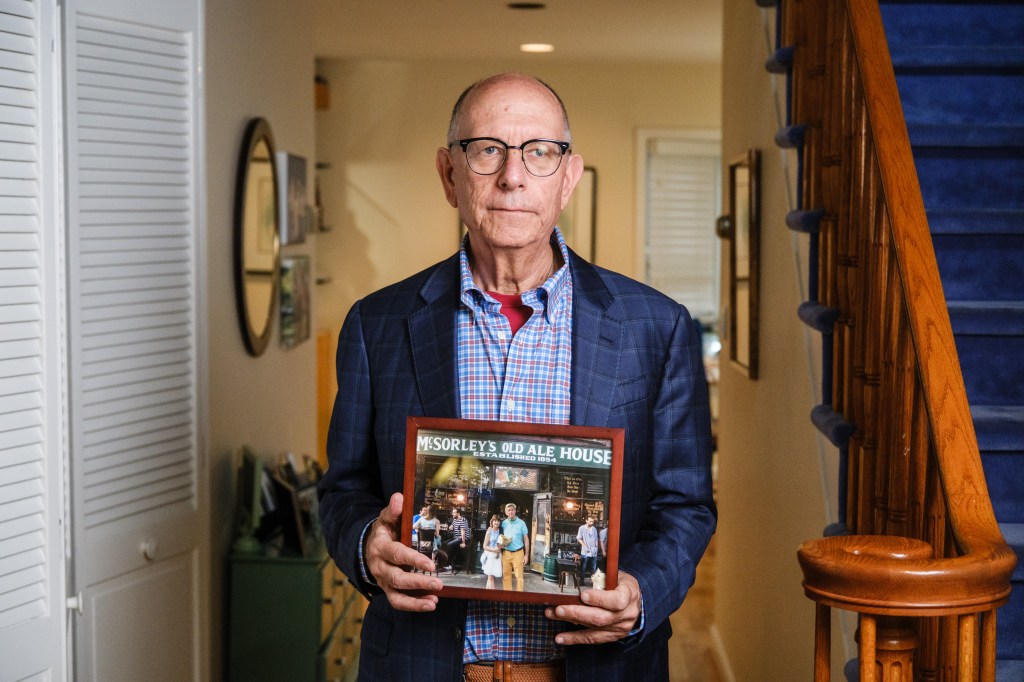 Michael Trager, 70, holds a framed photograph of himself and his late wife Cara.