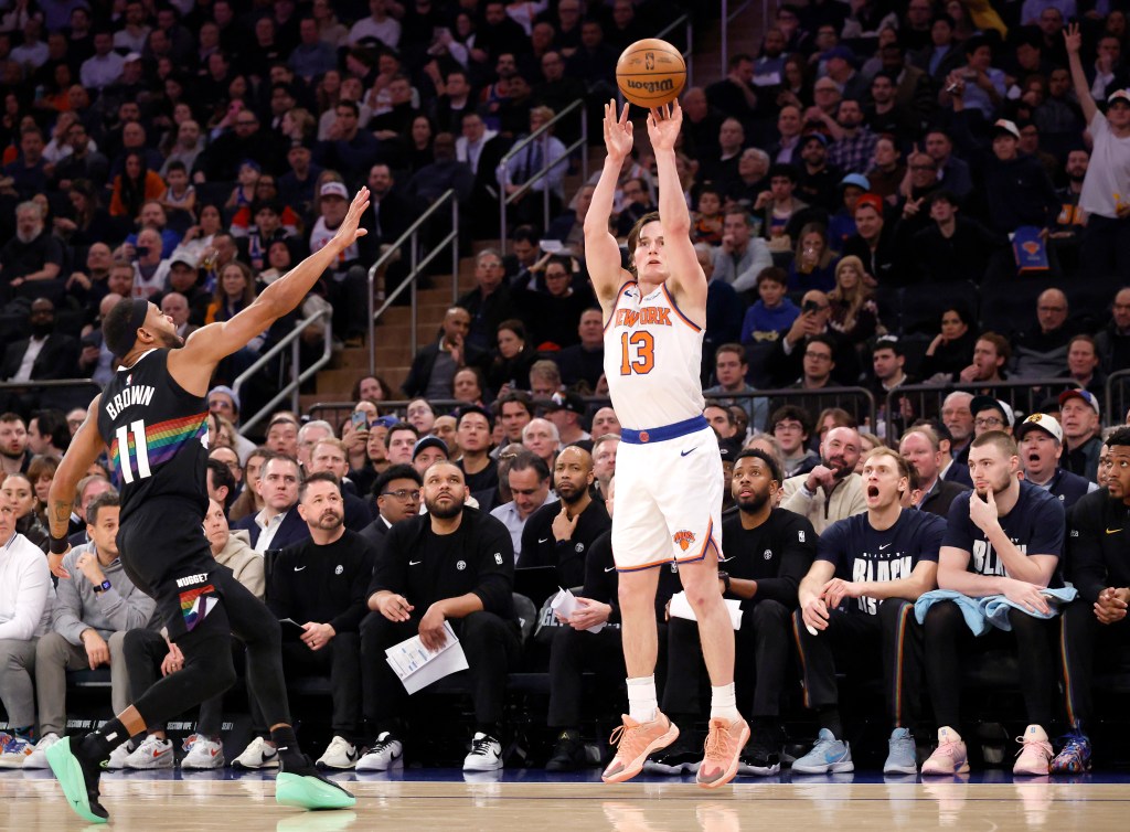 New York Knicks guard Tyler Kolek shoots a three-point shot over a Denver Nuggets player.