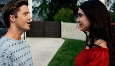 Paulina Reyes, right, and a co-star smile at each other in a scene from the film, standing in a suburban driveway.