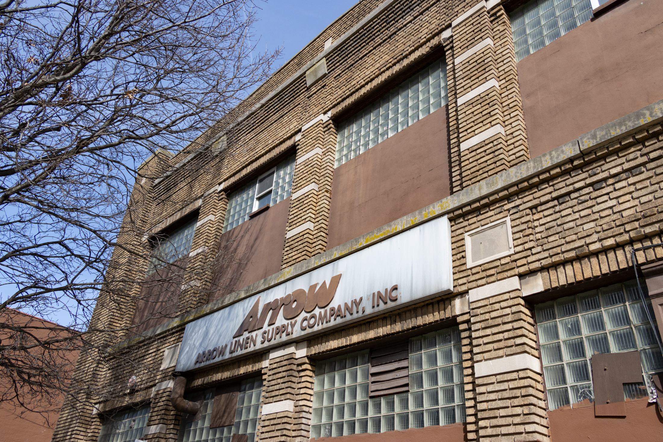 brick building with arrow linen supply co sign