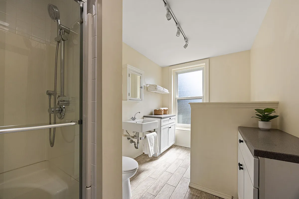 bathroom with a built-in shower, white fixtures