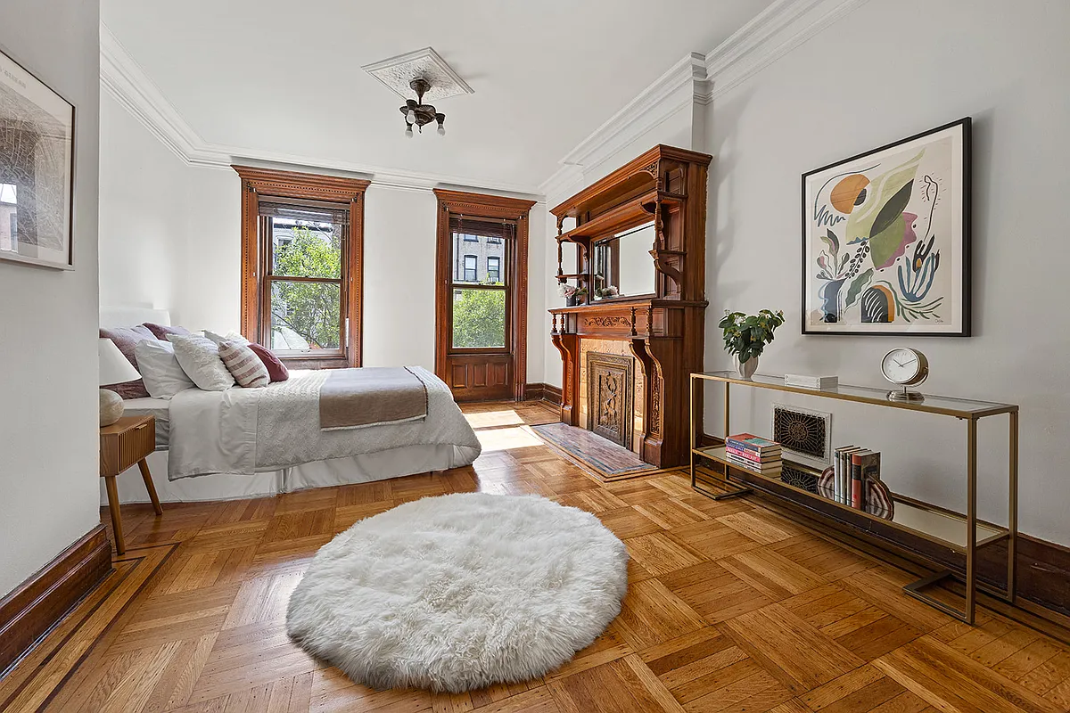 bedroom with mantel, wood floor,