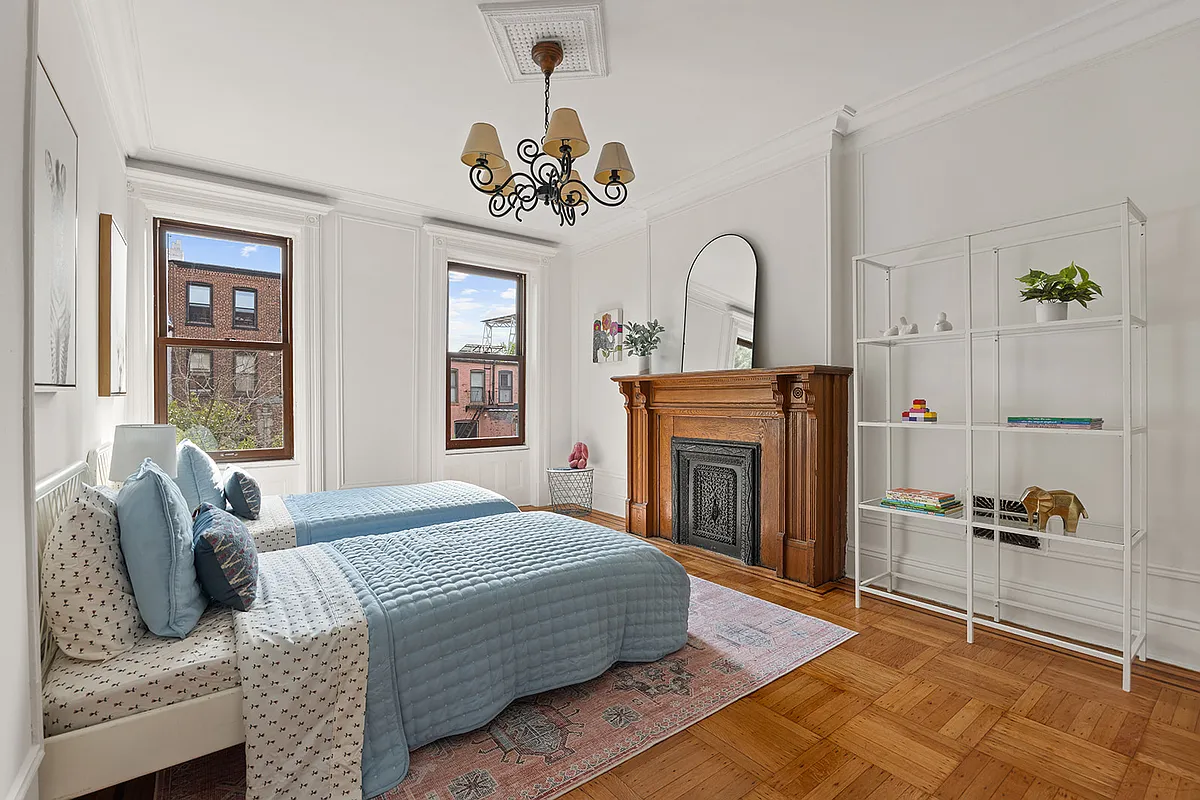 bedroom with mantel, wood floor
