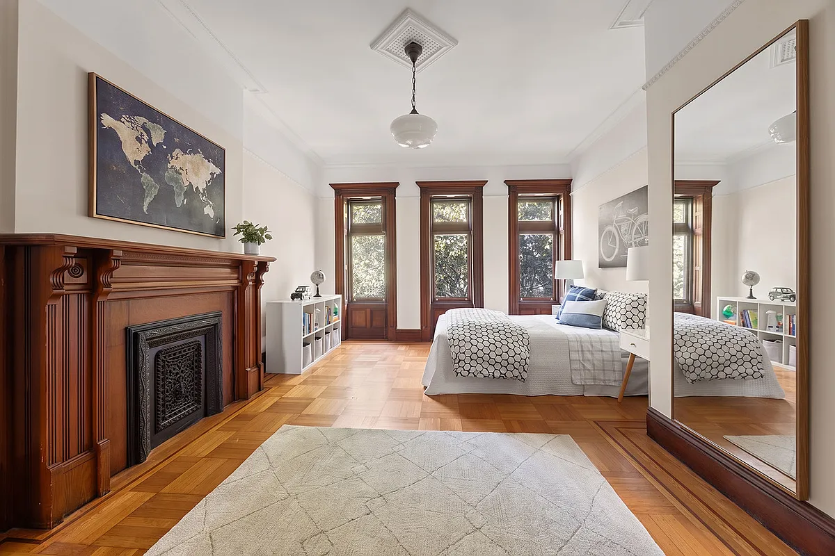 bedroom with mantel, wood floor,