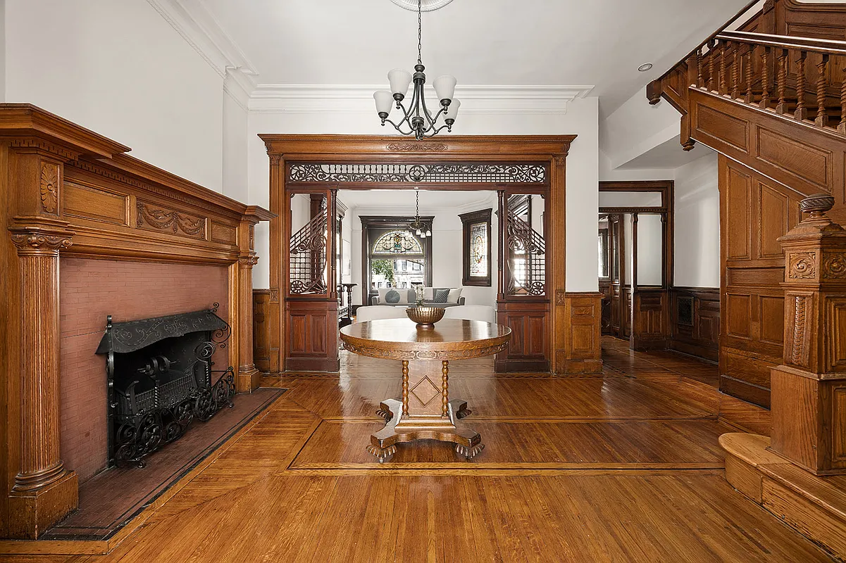 middle parlor with mantel, fretwork, wood floor, stair
