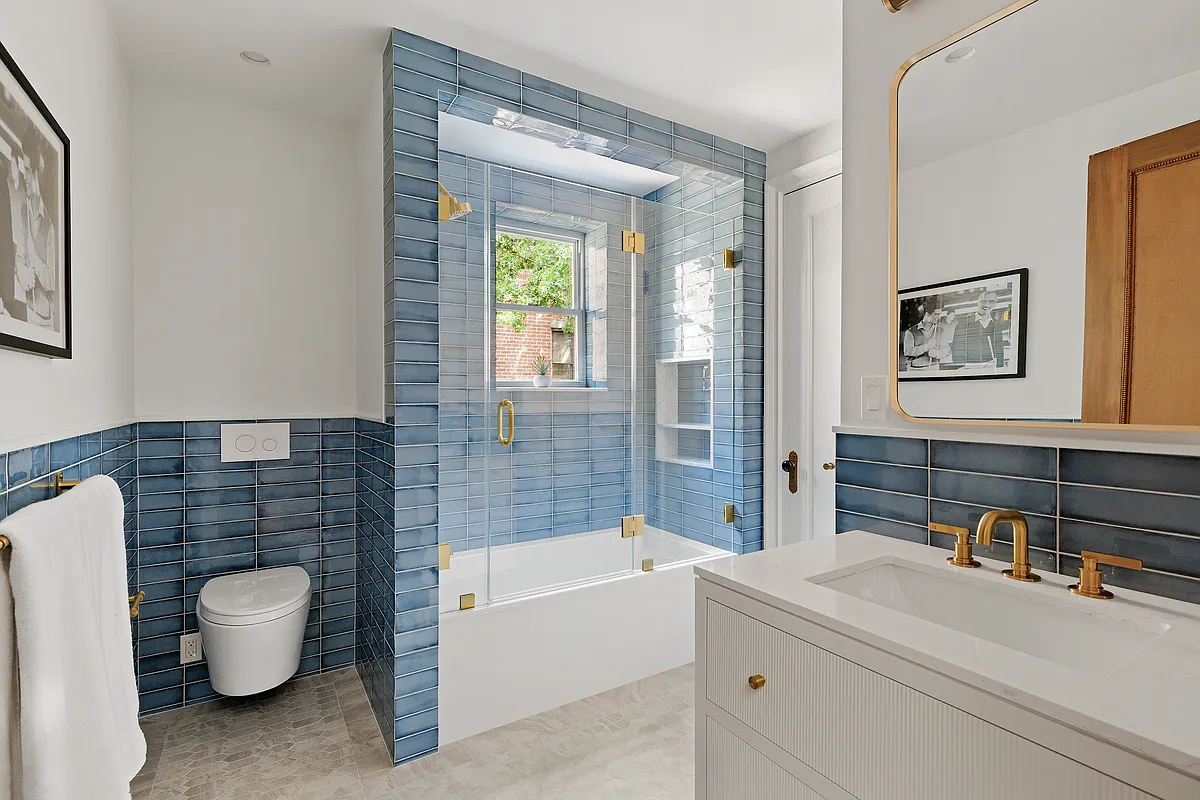 bathroom with blue wall tile, white fixtures including a tub