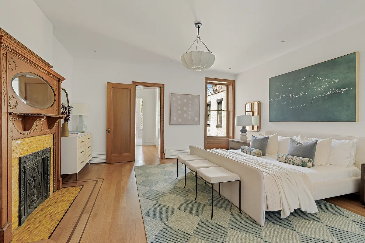 bedroom with white walls, wood mantel with yellow tile surround