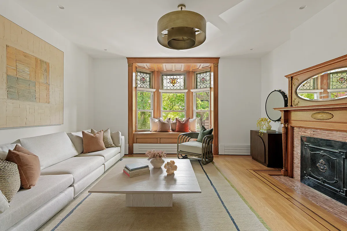 bedroom set up as a den with a window seat, mantel, wood floor