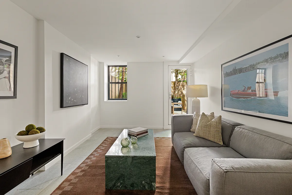 garden level den with white walls, tile floor, glass door out to garden