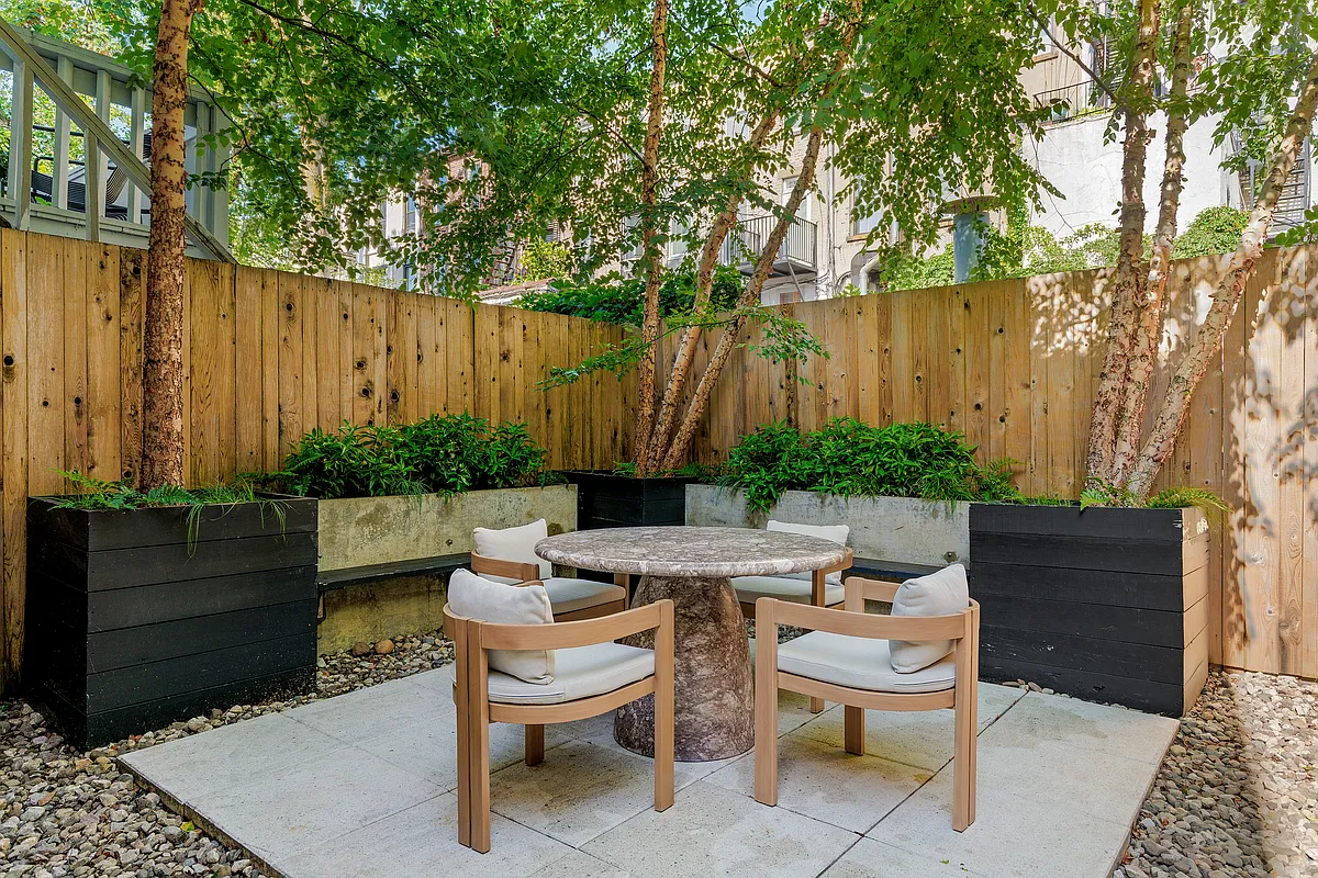 rear yard with wood fence and pavers on top of gravel for a dining area