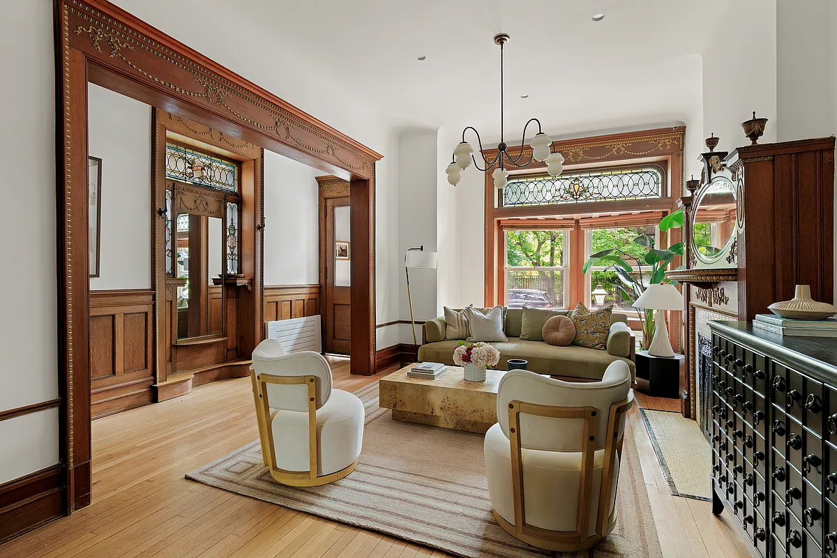 parlor with wood floor, view to entry with mirror, wainscoting