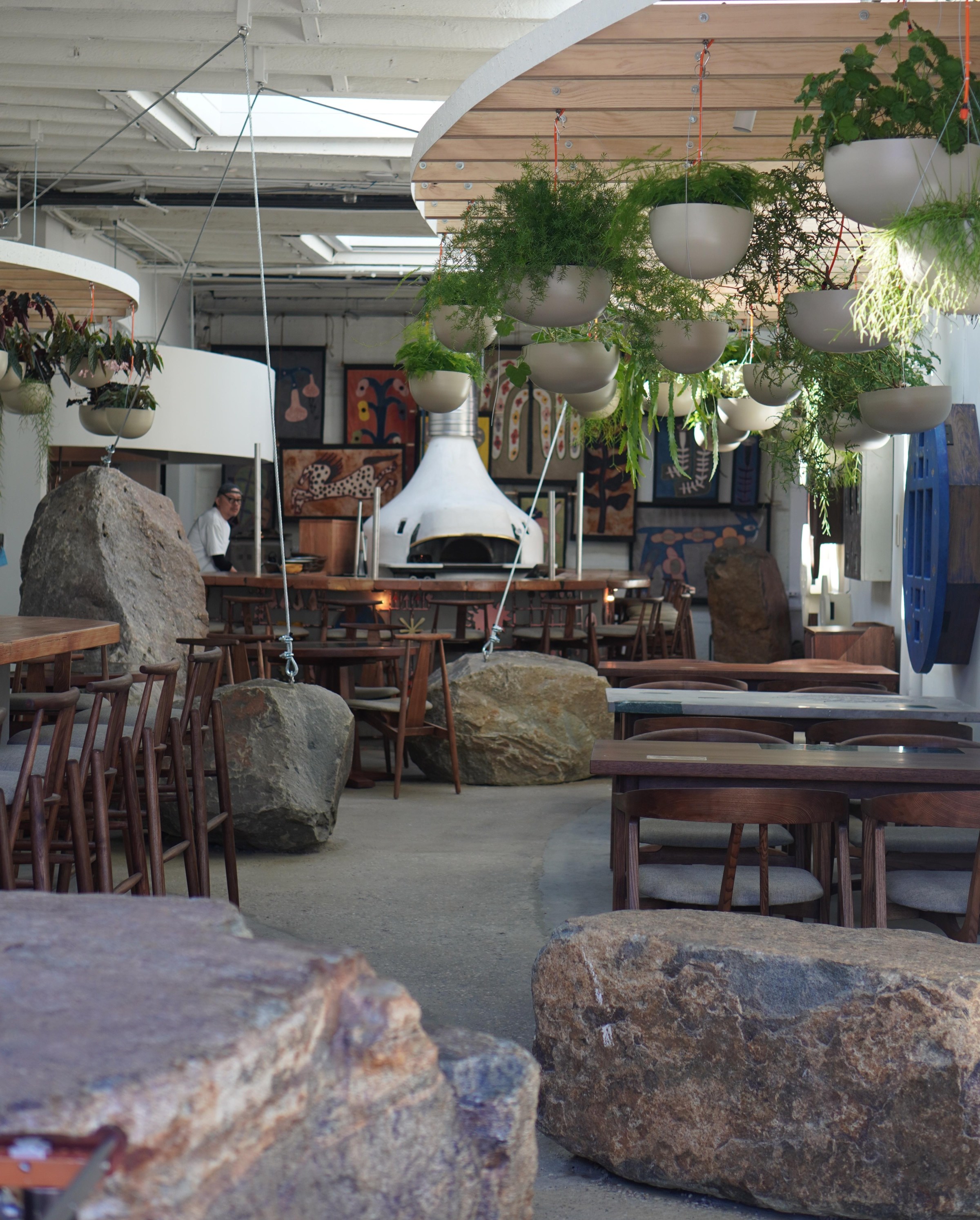 an image showing the interior of the brooklyn location of pizza 4p’s. it features six large stones throughout the space.