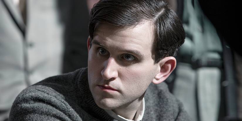 Harry Melling sitting and looking at someone off camera in The Queen's Gambit