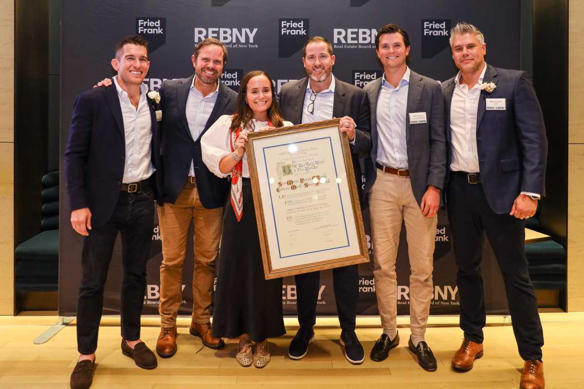 group of people holding a large plaque