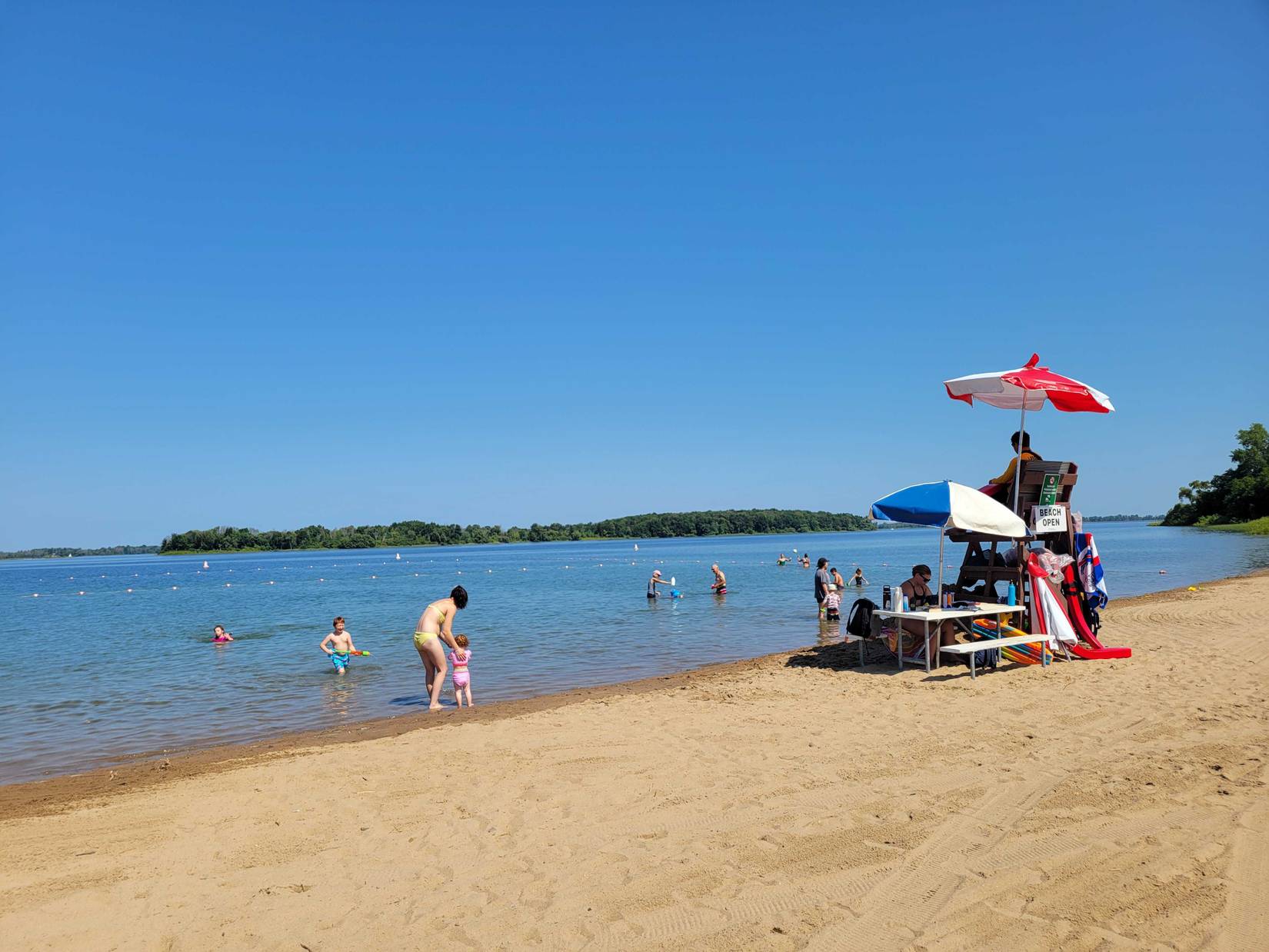 People enjoy the beach along the St. Lawrence River at Robert Moses State Park in Massena, NY