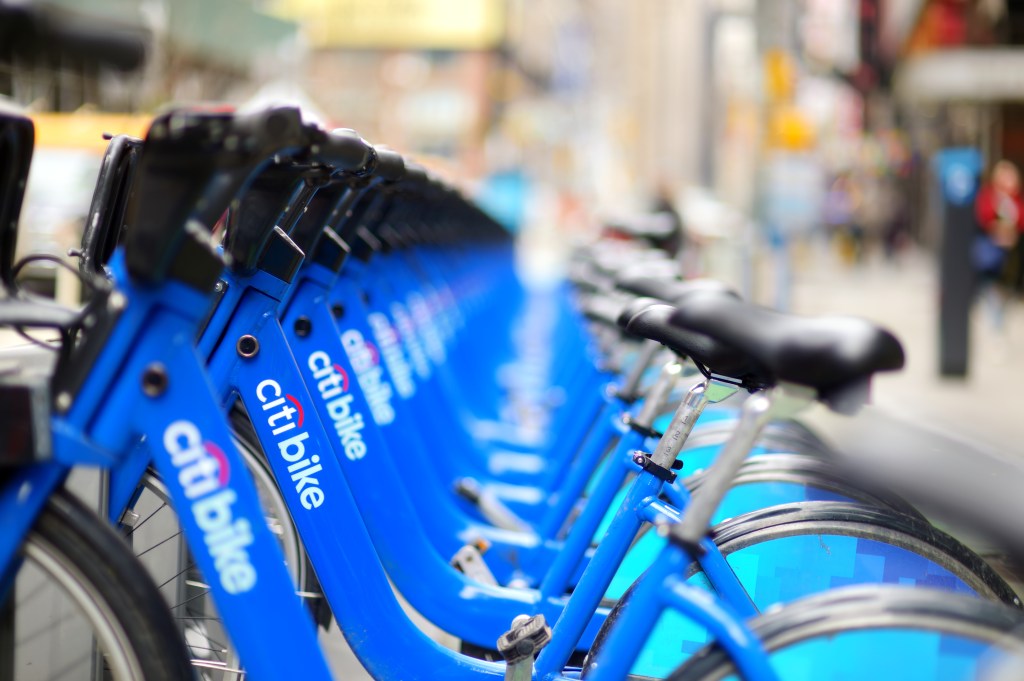 A row of blue Citi Bike rental bicycles lined up at a docking station in New York City.