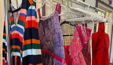 A clothing rack with four bright pieces of clothing hanging from it is seen.