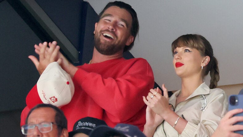 Travis Kelce and Taylor Swift sitting courtside at a game.