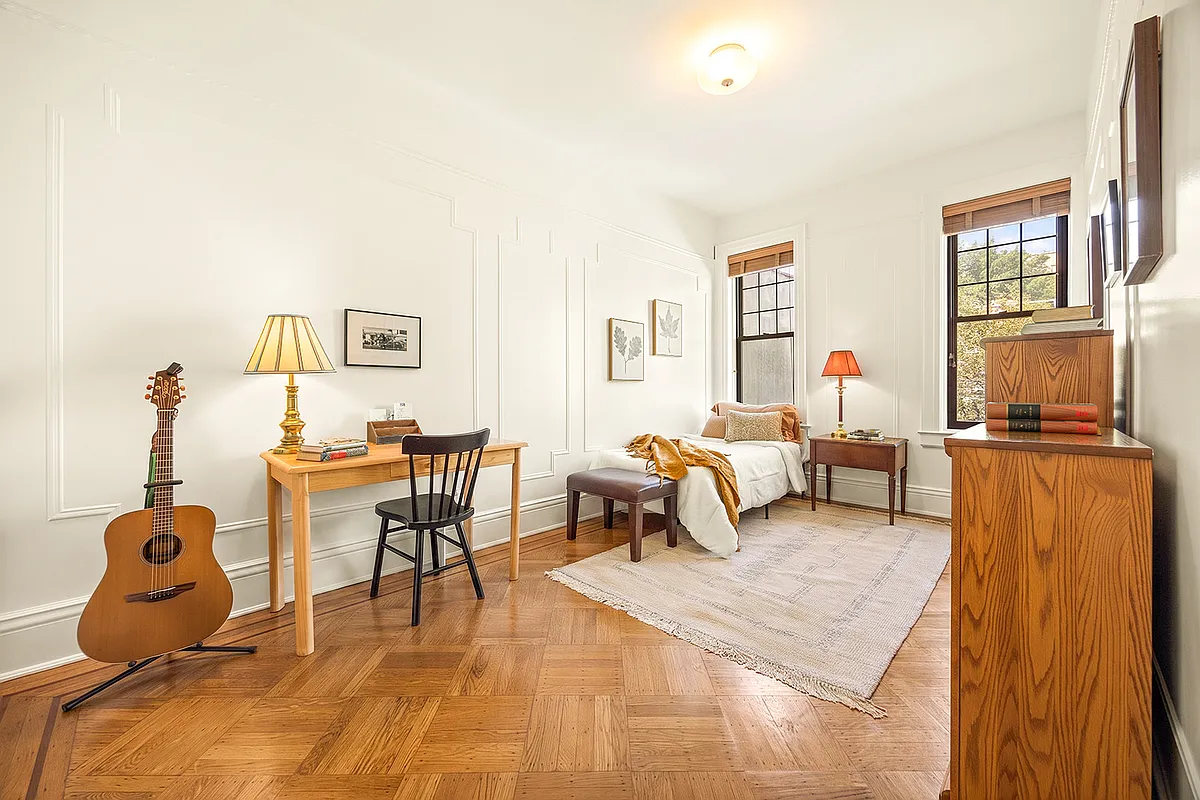 bedroom with wood floor, wall moldings