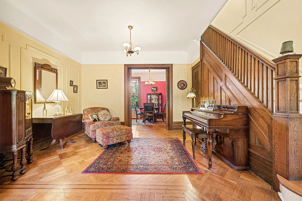 room with wood floor, stair, wall moldings